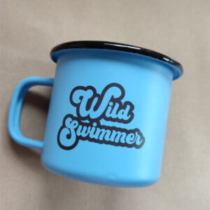 This is an enamel mug with the words "Wild Swimmer" printed on both sides. Designed and printed in Ireland.